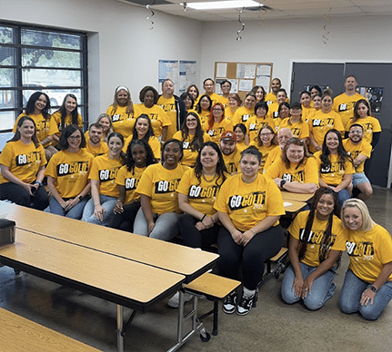 A group of people seated ows. They all wear yellow shirts that say Go Gold on the front.