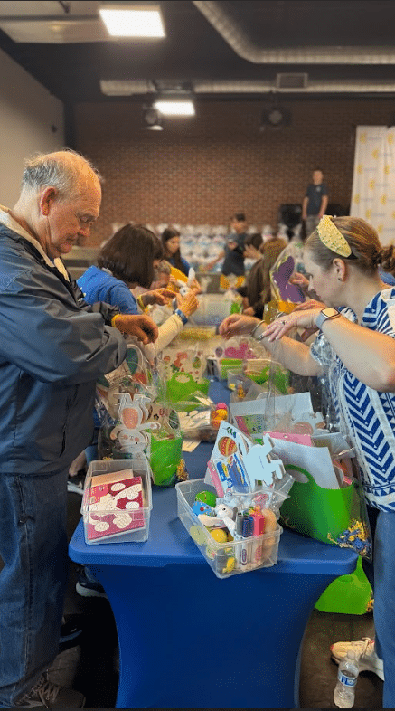 A table of goodie backs with people sorting them