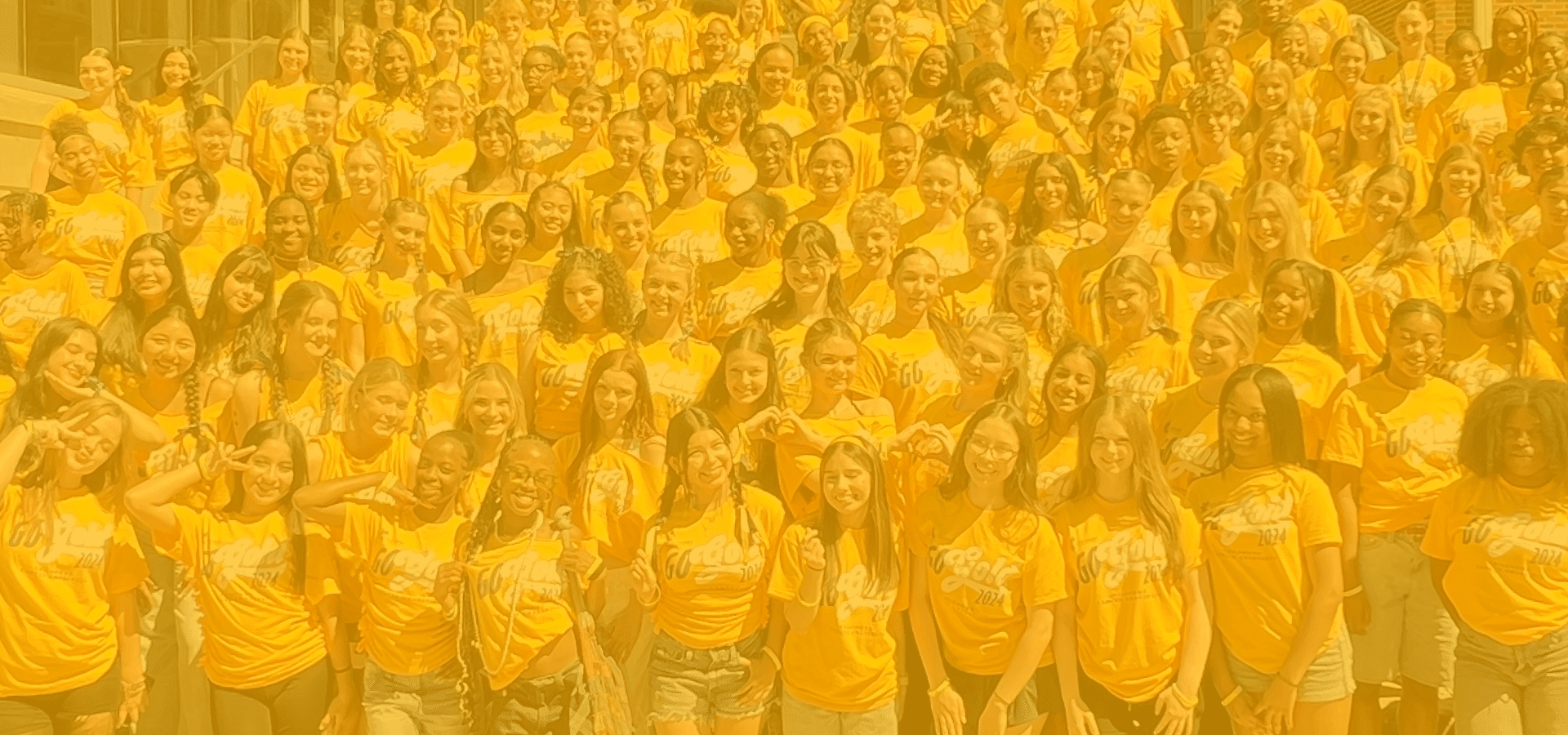 A large group of children in yellow GoGold t-shirts standing together