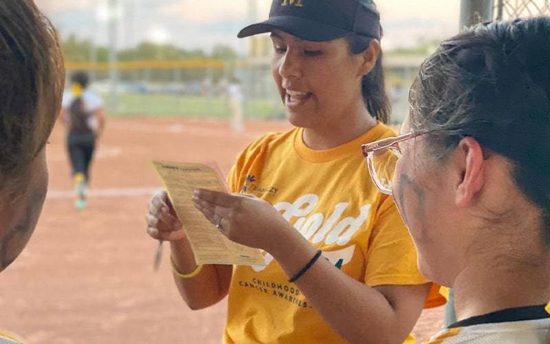 a woman reading a list out on a sports field
