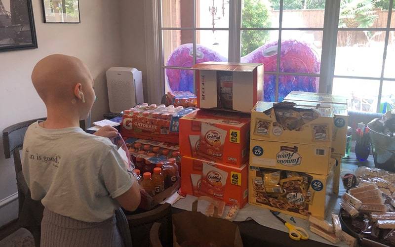 a person standing behind a bunch of food boxes