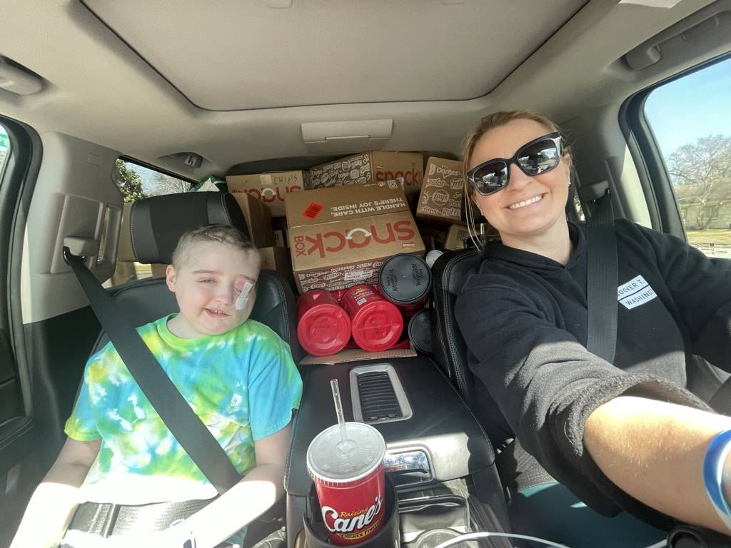 a parent and child in a van loaded up with boxes