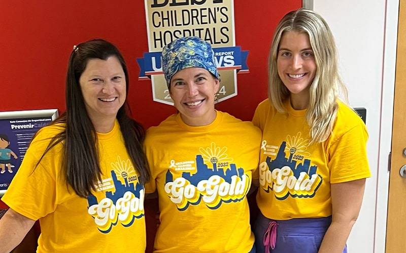 3 women with go gold t-shirts on