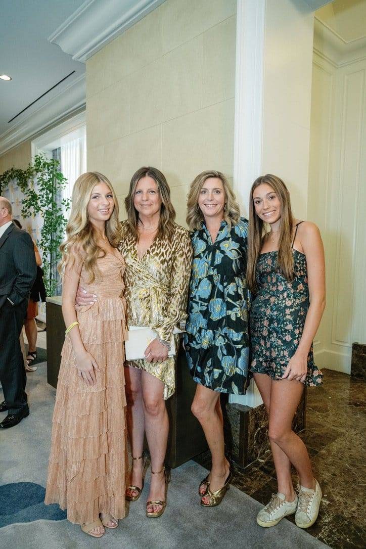 a group of 4 women posing for a photo