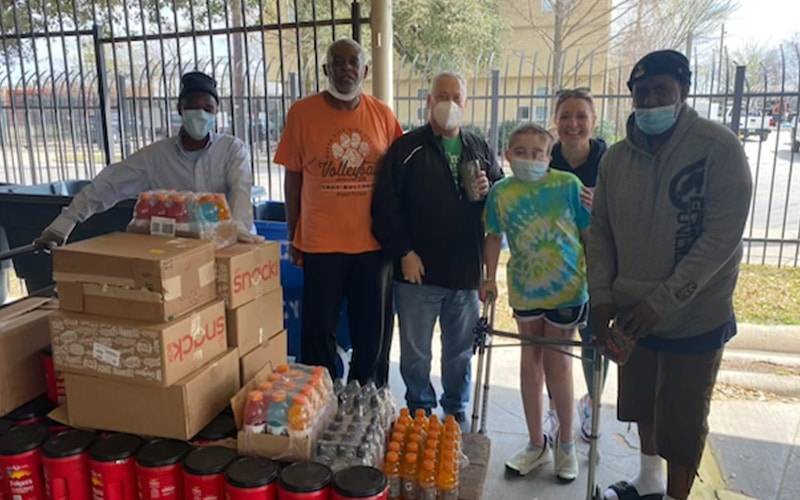 a group of people wearing face masks and standing in front of boxes 